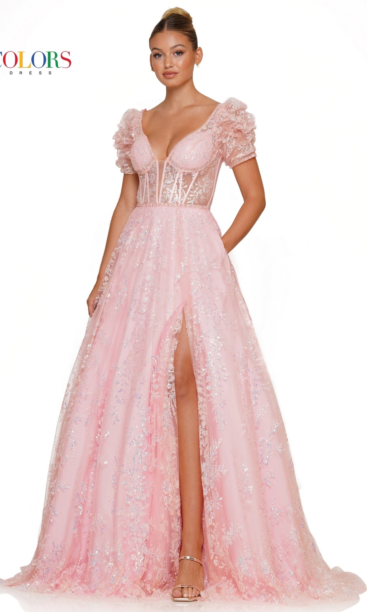 A woman models the Short-Sleeve Long Glitter A-Line Prom Dress 3243 in light pink, featuring puffed short sleeves, a deep neckline, floral details, and a high slit, set against a plain white background.